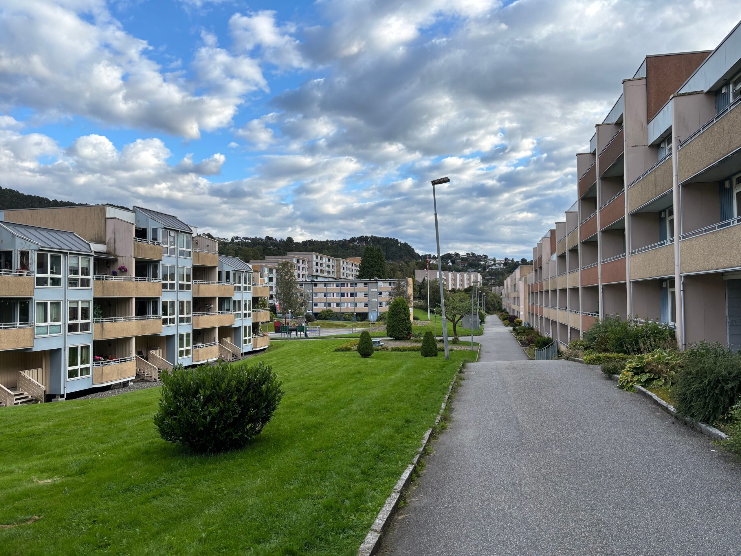 A serene view of residential buildings and greenery in a peaceful neighborhood in Bergen, Norway.